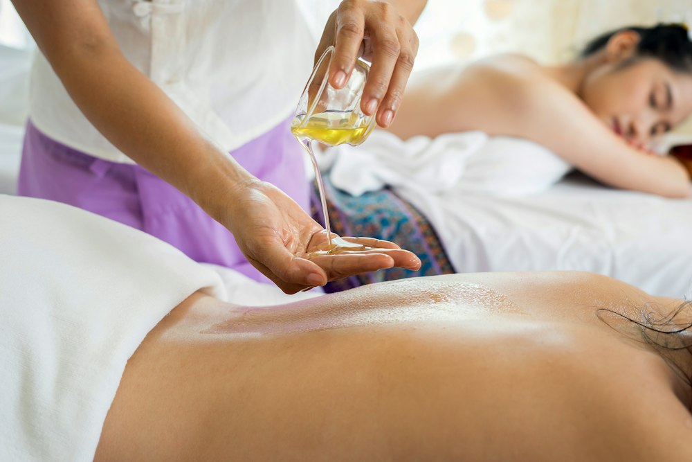 Therapist pouring warm oil for a relaxing back massage