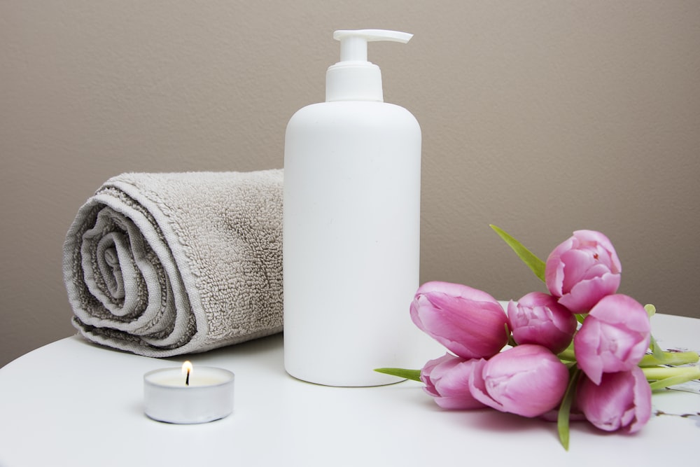 Soft towels, massage oil and fresh flowers in a calm spa setting